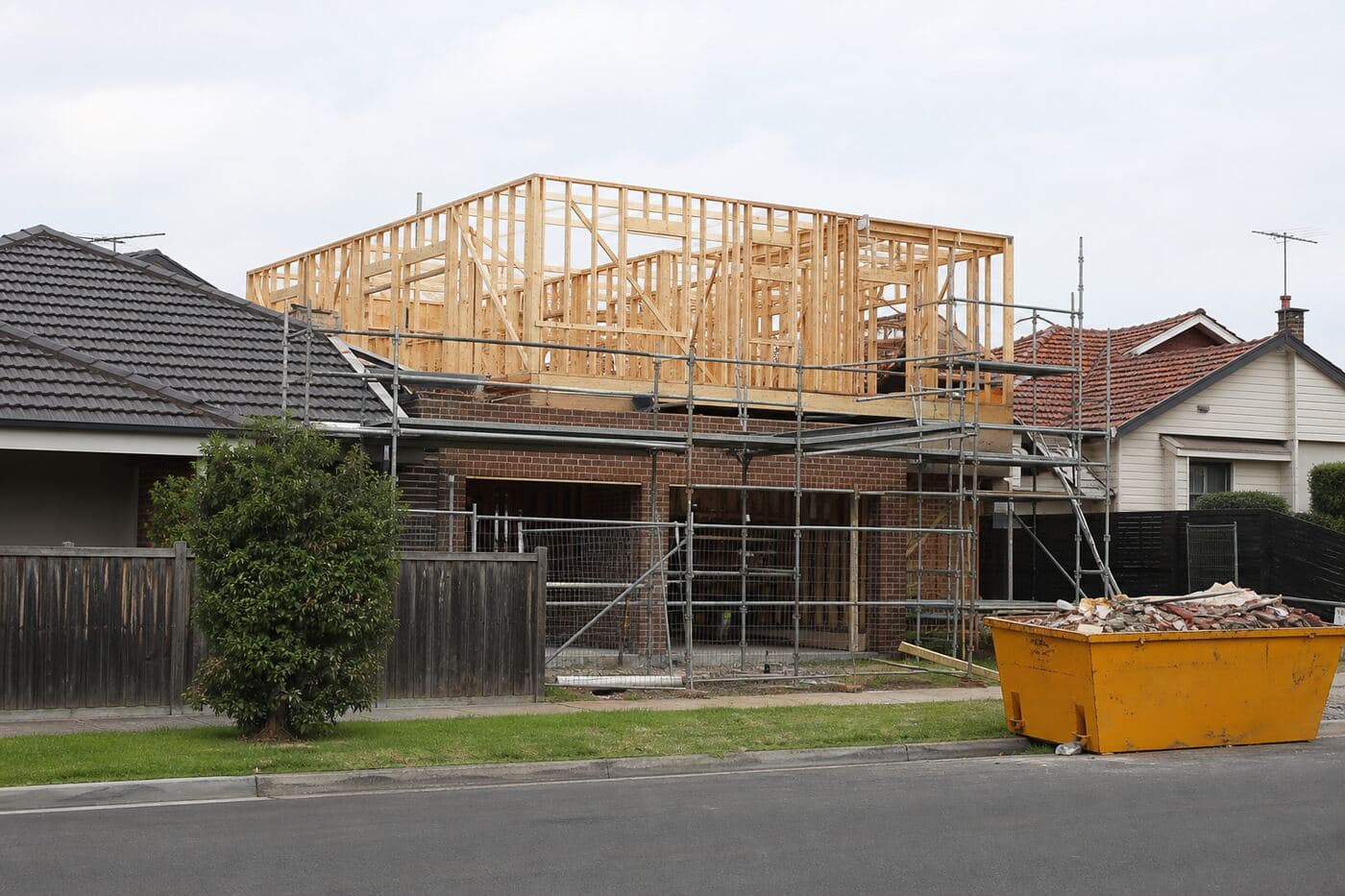 Residential building work on a suburban street next to existing houses