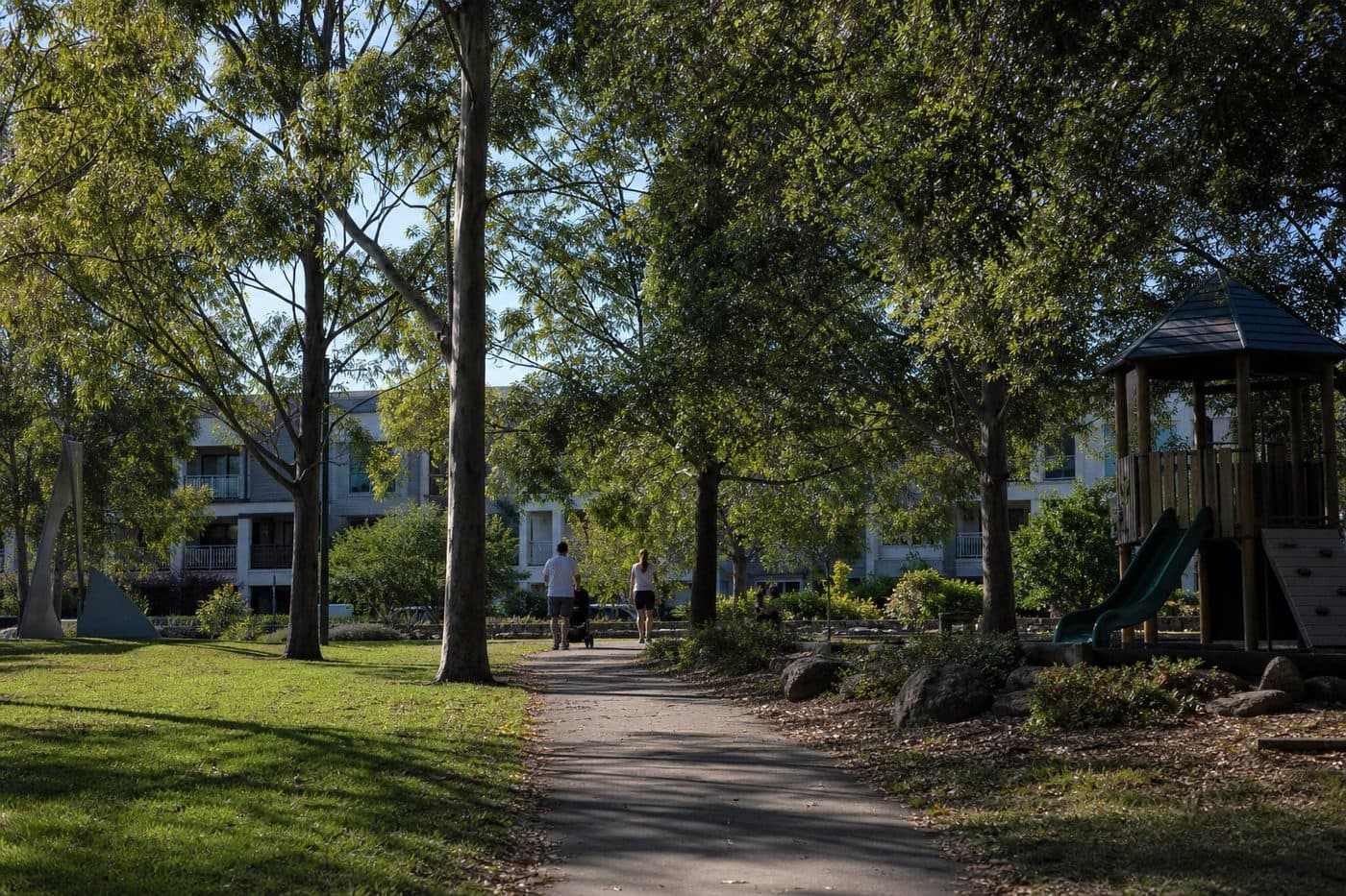 Leafy Australian suburban park and playground with homes beyond the trees